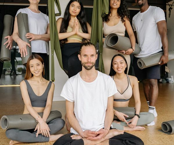 Group of diverse women smiling and preparing for a yoga class.