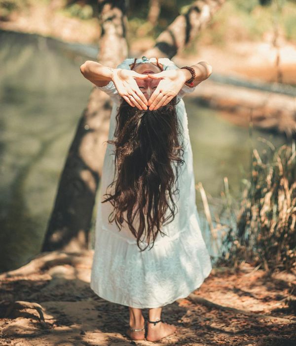 Woman in a calm yoga pose in a bright, serene environment.